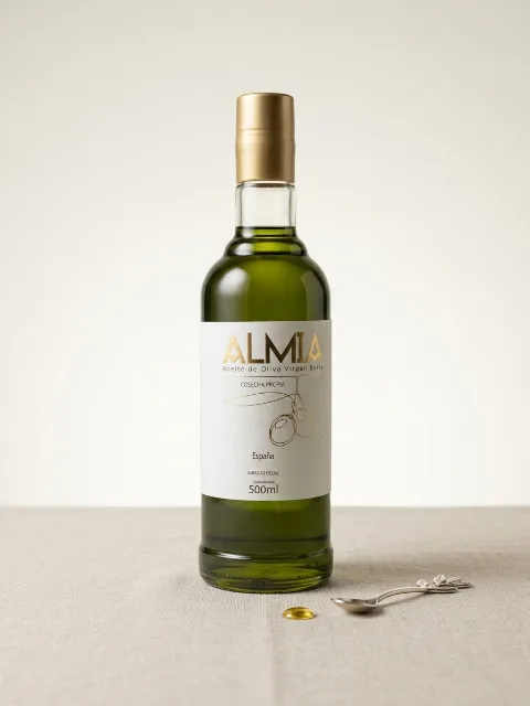Botella de Almia de 500 ml, de vidrio con cápsula dorada, sobre fondo claro